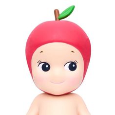 a small doll with an apple on top of it's head, sitting in front of a white background