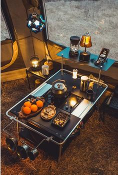 a camper's table with food on it in front of a tent window