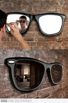 a man is taking a selfie in the mirror with his sunglasses hanging on the wall