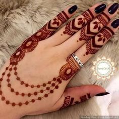 a woman's hand with henna tattoos on it