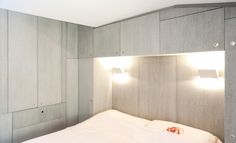 a bed sitting under two lights in a bedroom next to a wall mounted light fixture