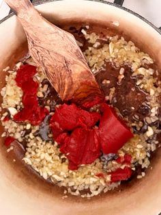 a wooden spoon in a pot filled with food