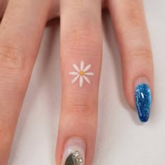 a woman's hand with a blue and white manicure on her left thumb