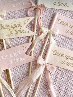 pink and gold wedding cake toppers with ribbons on them for guests to take home