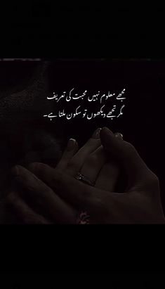 two hands holding each other in the dark with an arabic text above them that reads,