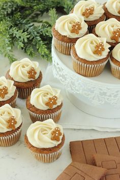 cupcakes with white frosting and star decorations on top, surrounded by cookies