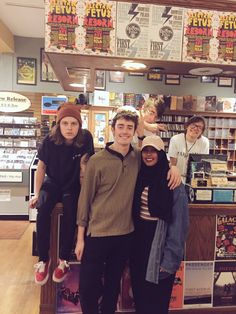 a group of people standing in front of a book store with their arms around each other