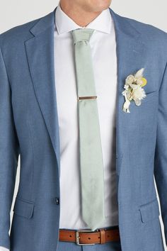 a man in a blue suit with a flower on his lapel and a white shirt