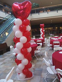 red and white balloons in the shape of a heart are on display at an event