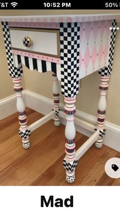 a pink and black checkerboard desk with two drawers on the top, one drawer is