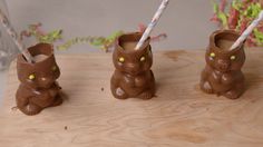 three chocolate bunny cups with straws in them