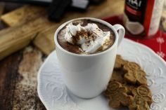 a cup of hot chocolate with marshmallows and graham crackers on the side