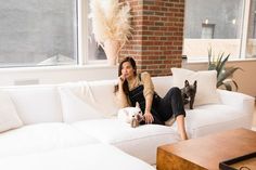 a woman sitting on a couch with her dog