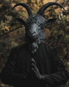 a man wearing a goat mask and holding his hands together