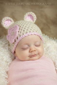 a newborn baby wearing a knitted bear hat