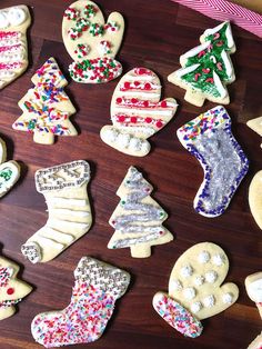 many decorated cookies are on a wooden table