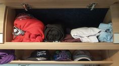 several hats and blankets are sitting on the shelves in a closet, all neatly folded