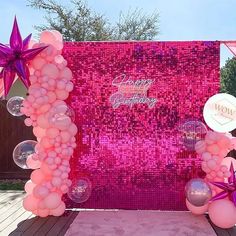 a pink and purple birthday backdrop with balloons