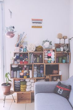 a living room filled with furniture and lots of crafting supplies on top of shelves