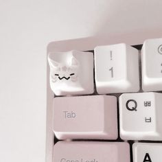 a white cat head on top of a pink computer keyboard with the word tab written below it