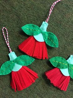 three christmas ornaments made out of felt on the floor with candy canes attached to them