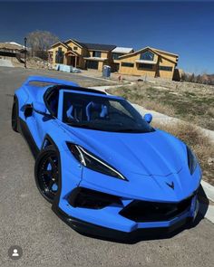 a blue sports car parked in front of some houses