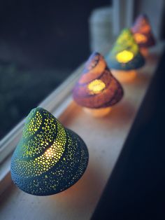 three small vases sitting on top of a window sill next to each other