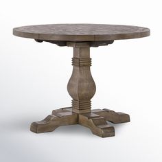 a round wooden table with two pedestals on one end and an oval base on the other