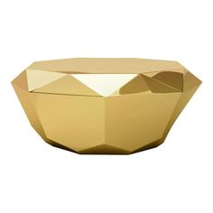 a gold vase with geometric shapes on the top and bottom, sitting in front of a white background