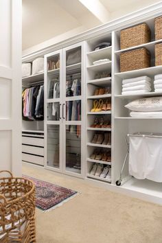 an organized closet with white shelving and baskets