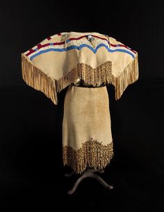 an old native american headdress with fringes and beads on it's sides