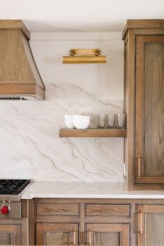 a kitchen with marble counter tops and wooden cabinets in the corner, next to an oven