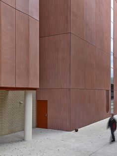 a person walking on the sidewalk in front of a building