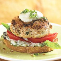 a sandwich with tomatoes, lettuce and mayonnaise on it sitting on a green plate