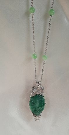 This lovely vintage signed Nolan Miller silver tone pendant necklace features Peking glass beads, sparkling clear Swarovski crystal rhinestones and a large carved faux jade centerpiece. The pendant and silver tone chain are marked Nolan Miller. The necklace is 36 in. L and the pendant is 2-7/8 in. L. This necklace is in very good vintage condition. Elegant Crystal Pendant Necklaces, Elegant Crystal Pendant Necklaces With Stones, Elegant Silver Crystal Necklaces With Stones, Elegant Jade Pendant Crystal Necklace, Elegant Round Jade Crystal Necklaces, Elegant Jeweled Rhinestone Pendant Necklace, Elegant Jade Necklace With Large Pendant, Elegant Jade Necklace With Stones, Elegant Pendant Crystal Necklaces With Rhinestones