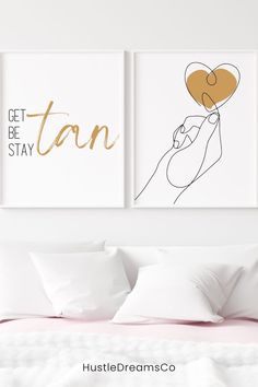 two art prints on the wall above a bed with pillows and white sheets in a bedroom