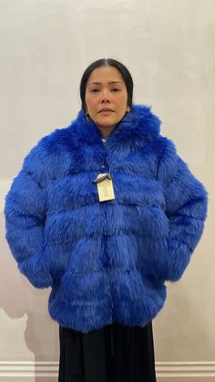 The electric blue faux fur coat is soft, fluffy and luxurious this long sleeve faux fur coat is cozy with a hood and has a voluminous silhouette. Fully lined in black and silver-tone zip-up closure at front. Hooded Fluffy Faux Fur Coat, Hooded Faux Fur Coat With Fluffy Detail, Fluffy Hooded Faux Fur Coat, Blue Faux Fur Winter Coat, Blue Faux Fur Coat For Winter, Winter Blue Faux Fur Coat, Fluffy Blue Outerwear For Winter, Blue Fluffy Winter Outerwear, Blue Hooded Outerwear With Faux Fur Trim