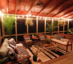 an outdoor living area with couches, chairs and potted plants