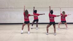 four girls in red shirts and black shorts are doing exercises on the dancefloor