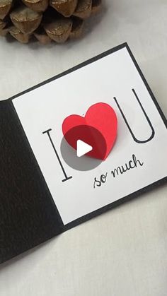 i love you so much card with paper heart and pine cone on white tablecloth