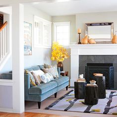 a living room filled with furniture and a fire place in front of a mirror on the wall