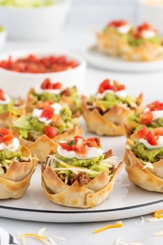 small appetizers with guacamole, tomatoes and other condiments