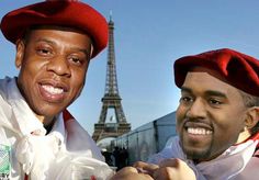 two men in red hats standing next to each other near the eiffel tower