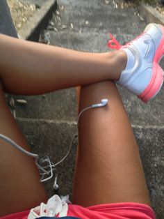 a woman's legs with ear buds attached to the side of her leg, while she is sitting down