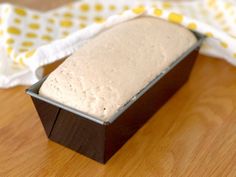 a loaf of bread sitting on top of a wooden table next to a cloth covered napkin