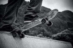 black and white photograph of a person on a skateboard at the top of a ramp