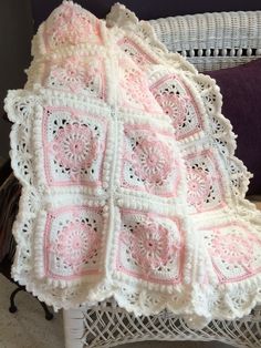 a crocheted blanket sitting on top of a wicker chair