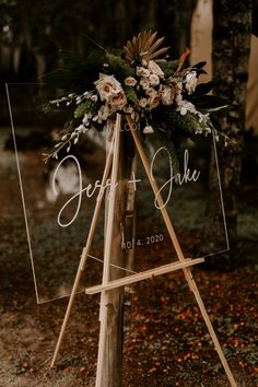 a wooden easer with flowers and greenery on it for an outdoor wedding ceremony