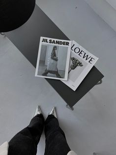 a person standing next to a skateboard on top of a white floor with black lettering