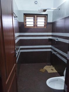 a bathroom with a toilet, sink and wooden door in it's stall area